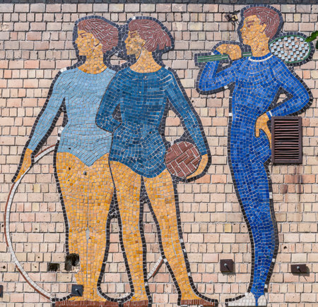 A mosaic depicting a schoolchildren with a sports equipment in an old school shabby brick wall. Close-up.  Kyiv, Ukraine, March 2021.のeditorial素材