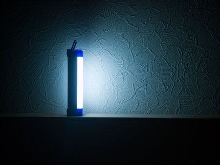 Cold LED backup emergency light in an apartment in the dark with free space for text on the right.の写真素材