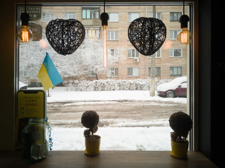 A view from the cafe window to a snowy street in winter. Kyiv, Ukraine - November 2022.のeditorial素材