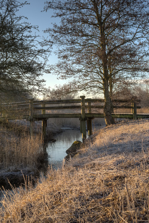 A small romatic bridge crosses a brook の写真素材