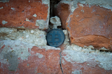 Bit coin on the old stone and brick wallの写真素材