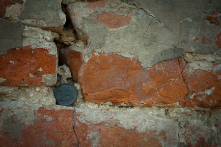 Bit coin on the old stone and brick wallの写真素材