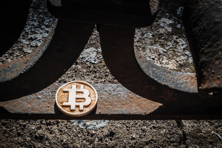 Light wooden bit coin on a steal rusty fence with shadows.の写真素材