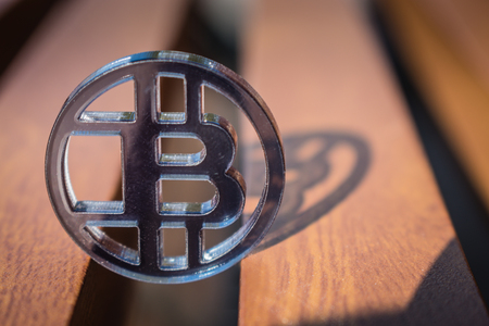 Plastic see thru bit coin on wooden background and lines.の写真素材