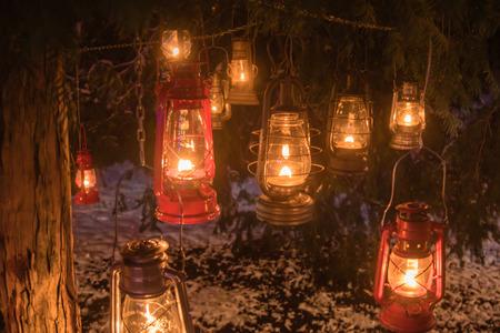 Oil lanterns hanging outside in winter snowed park