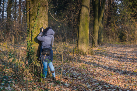 Girl at autumn in blue clothes exploring in the parkの写真素材