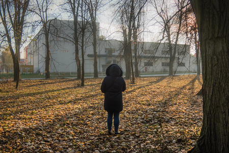 Girl at autumn in blue clothes exploring in the parkの写真素材