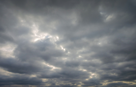 Dramatic sky with sunlight showing thru themの写真素材