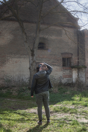 Man taking pictures in location with camera and exploring abounded placeの写真素材