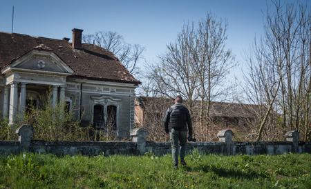 Man taking pictures in location with camera and exploring abounded placeの写真素材