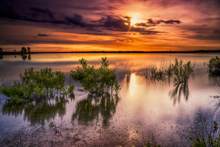 Vivid colors and reflections over serene Benbrook Lake in north Texas at dawnの写真素材