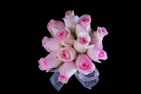 Top view of pink roses in a vase isolated on a black backgroundの写真素材