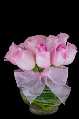 Pink roses in a vase isolated on a black backgroundの写真素材
