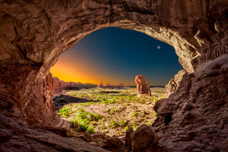 Eerie sunrise viewed from inside the Double Arches rock formation in Arches National Park, Utah