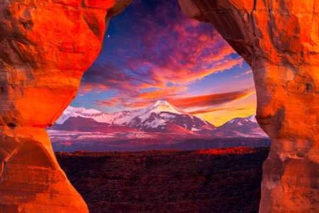 La Sal Mountains, as seen through Delicate Arch, on a colorful late afternoon in Arches National Park, Utahの写真素材