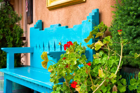 Red Flowers in Front of an Antique Bench in Santa Fe, NMの写真素材