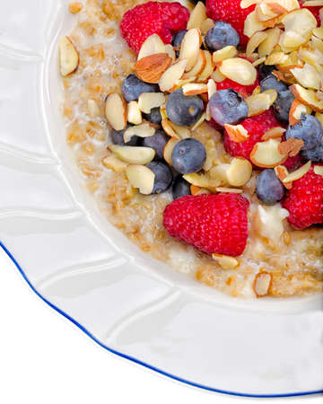 Ultra-healthy breakfast of steel cut oats cooked with egg whites and topped with fresh berries and sliced almondsの写真素材
