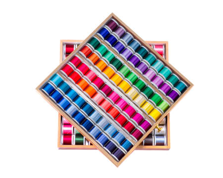 Spools of sewing thread arranged neatly in two drawersの写真素材