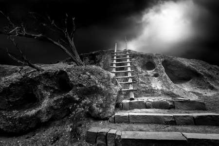 Ancient Indian cliff dwellings under an ominous sky in Bandelier, NMの写真素材