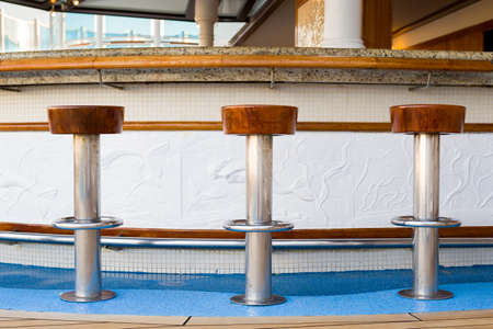 Mahogany stools at a marble top bar on a luxury cruise shipの写真素材