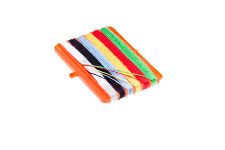 Multicolored thread wound on a spool  isolated on a white background