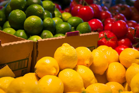 Colorful display of yellow lemons and other vegetables and fruit in a Canadian grocery marketの写真素材