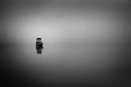 Foggy sunrise at Panorama Point in Vancouver, BC featuring a calm ocean with sunrise reflections on the smooth waterの写真素材
