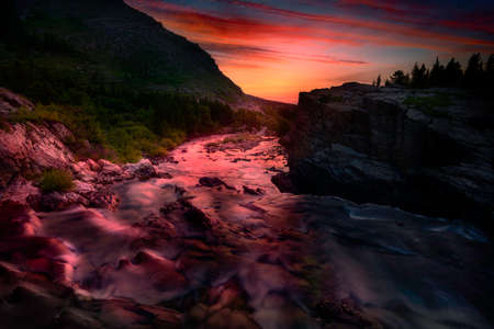 Colorful sunrise over the rapids of Swiftcurrent Creek in Glacier National Park, Montanaの写真素材