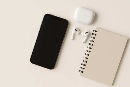 Gambar datar minimalis dari smartphone hitam dengan layar kosong, sepasang earbuds nirkabel putih di dalam casing pengisi daya, dan notebook berwarna krem di atas latar belakang putih. Sempurna untuk mockup, blog, atau presentasi yang berkaitan dengan teknologi, gaya hidup, produktivitas, atau konsep minimalis.の素材