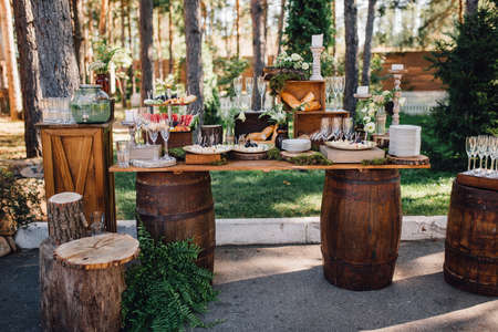 Reception table with snacks and lemonade stands on the lawn outside. Wedding decor. Rustic styleの写真素材