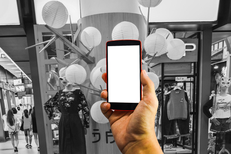 man hand holding the phone and white screen with blur black & white background. Smart phone with blank screen and can be add your texts or others on smart phoneの写真素材