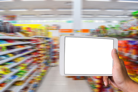 Close up of a man using tablet with blank screen and inside minimart motion blur background. tablet...