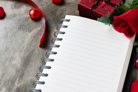 Valentines day background. Valentine hearts with open blank notebook on dark wooden background. Writing romantic lettersの写真素材