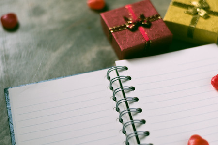 Valentines day background. Valentine hearts with open blank notebook on dark wooden background. Writing romantic letters.の写真素材