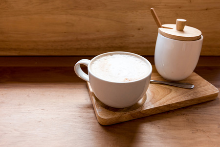 Hot art Latte Coffee in a cup on wooden table and Coffee shopの写真素材