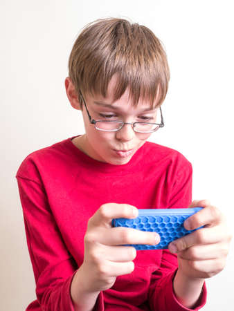 Teen boy playing games on his cell phoneの写真素材