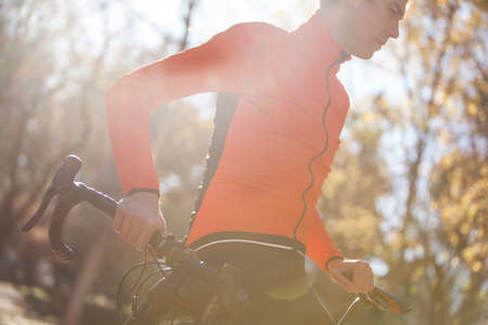 cyclist riding in the park with leaves on the ground in autumn 06の写真素材