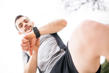 runner looking at his watch from belowの写真素材