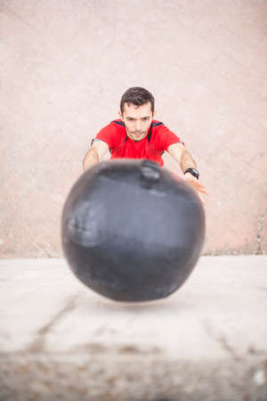 man training with the medicine ball against the wall aerial visionの写真素材