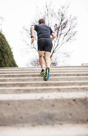 black runner climbs stairs from the back black runner climbs stairs from the back