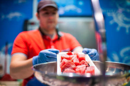 fishmonger weighing fish in the fish storeの写真素材