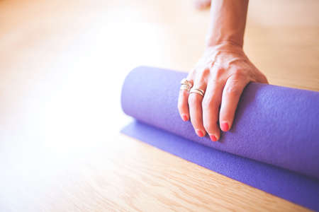 Yogi rolls the mat with one handの写真素材