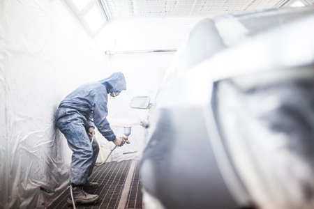 painter posing in front of the booth before painting a carの写真素材