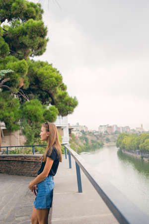 The girl is beautiful. On the background of the river. The view from the top. panorama. A stone fence. Old Tbilisiの写真素材