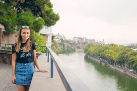 The girl is beautiful. On the background of the river. The view from the top. panorama. A stone fence. Old Tbilisiの写真素材