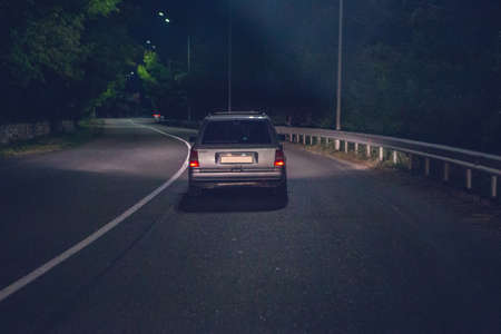night car driving on a winding road. Dark lights.の写真素材