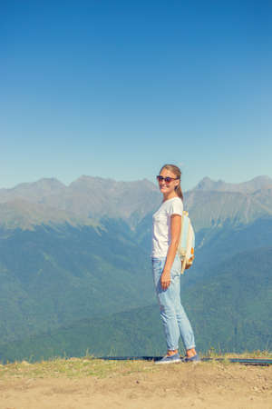 Happy woman traveler in the mountains and the landscape of mountains and blue sky Travel lifestyle concept of adventure summer holidays.の写真素材