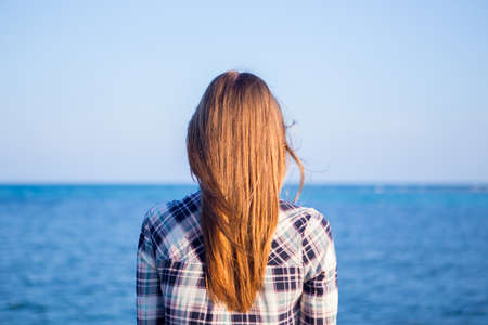 Young girl on blue sea background. Tropical country