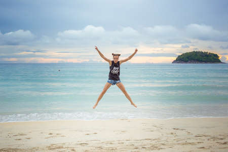 Young girl on blue sea background. Tropical country. Beach waves. Sunset. Dawn. Thailand Phuket Kataの写真素材