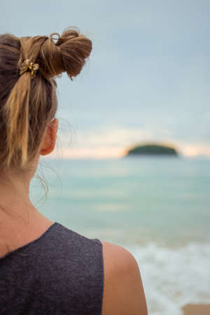 Young girl on blue sea background. Tropical country. Beach waves. Sunset. Dawn. Thailand Phuket Kataの写真素材